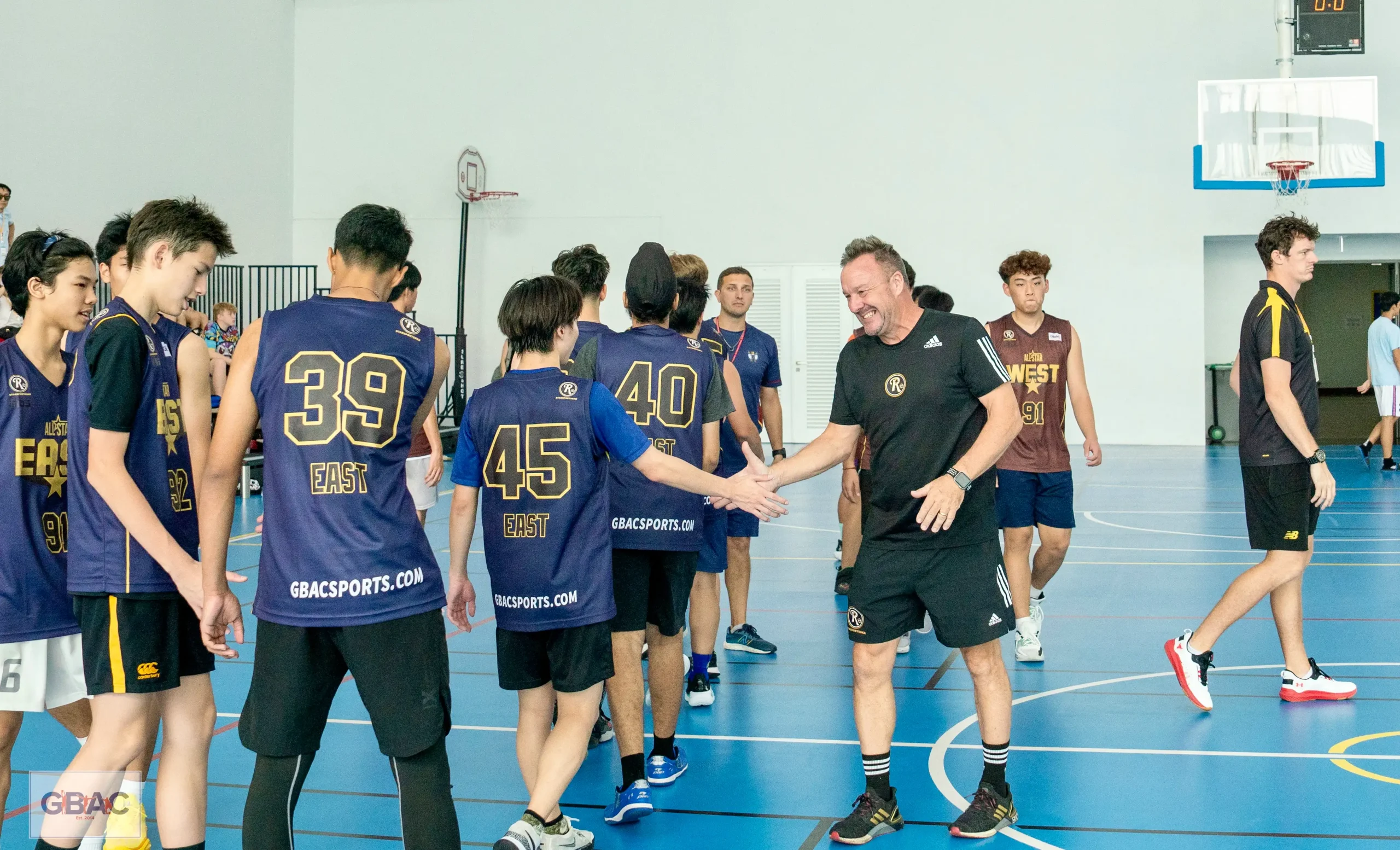 Ivan Rock smiling while exchanging post-match handshakes during GBAC All-Stars