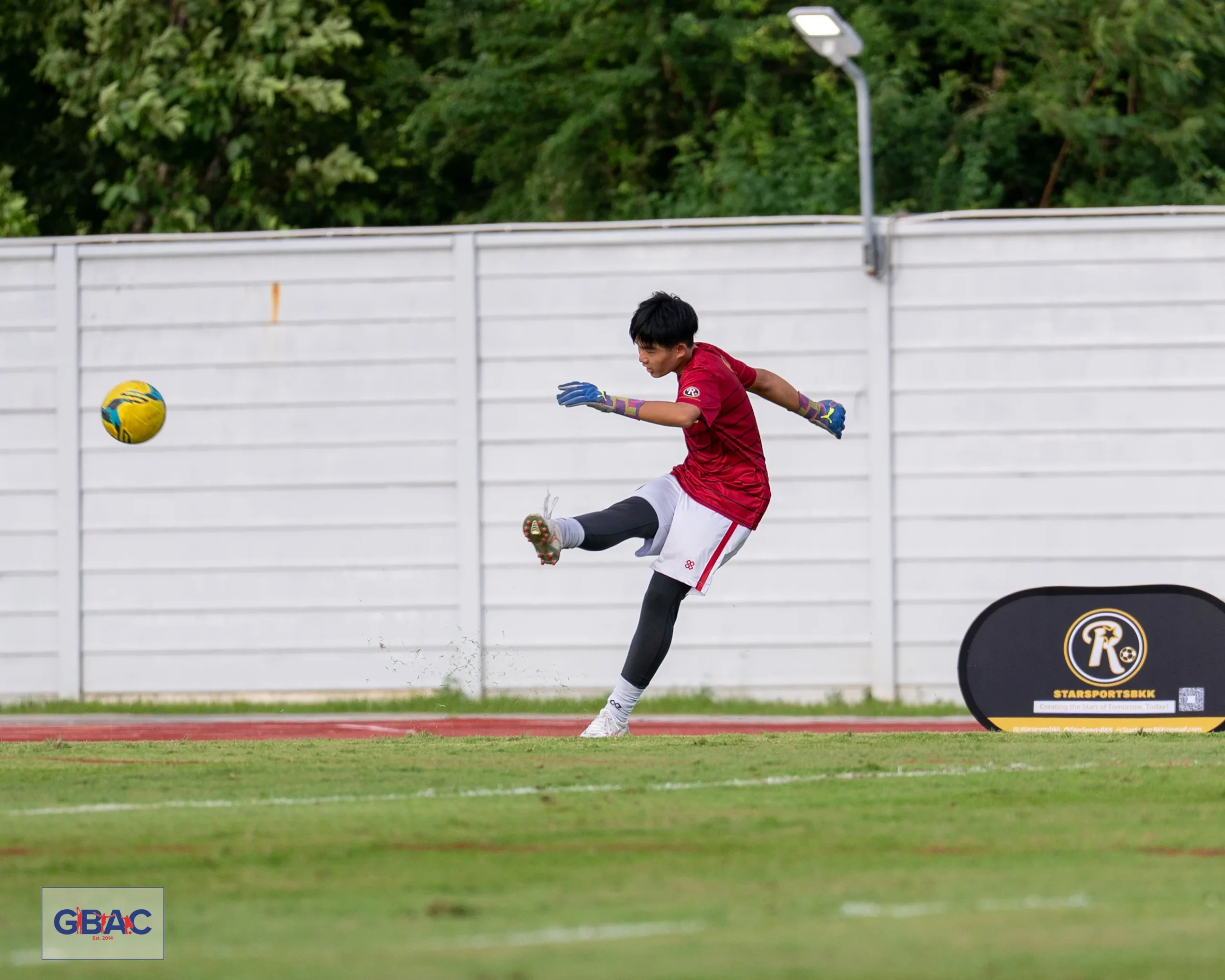 A player in red jersey kicks the football during a GBAC event